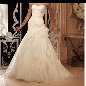 This strapless sweetheart gown has an asymmetrical pleated dropped waist.